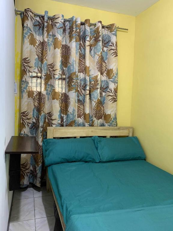 a small bedroom with a bed with a curtain at Stay at Amazing Grace, whole unit- VCDU subdivision , Mabini Plains in Mabini