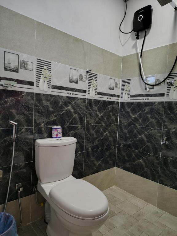 a bathroom with a white toilet and a shower at Sunee'S Home Stay in Ahangama