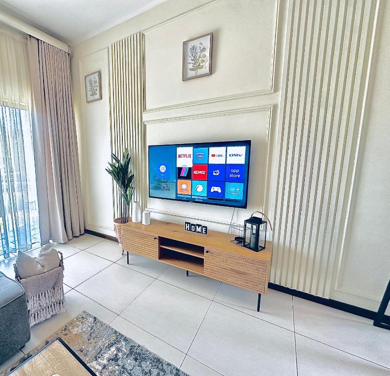 a living room with a flat screen tv at 2Bed in exquisite golf estate! in Roodepoort