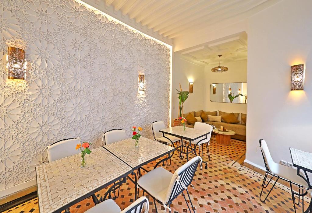 un restaurant avec des tables, des chaises et un canapé dans l'établissement Riad Dar Beldia and Spa, à Marrakech