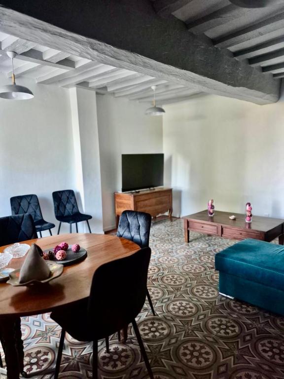 a living room with a table and a couch at Gîte de la Coup'Neuve in Chemilli