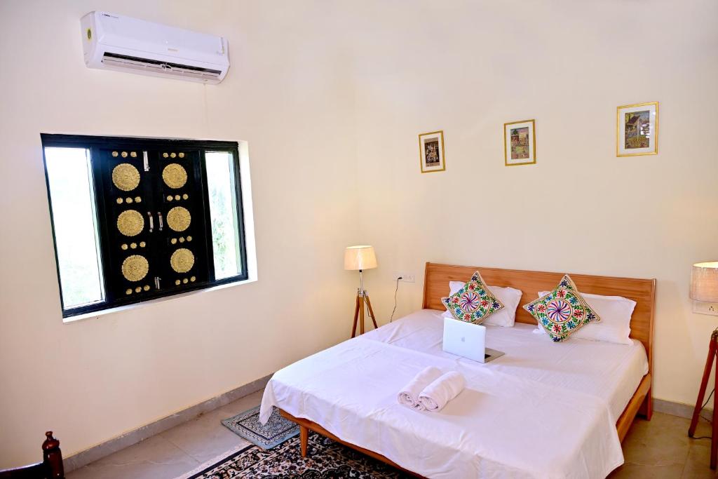 a white room with a bed and a window at Jaipur Eco Village in Jaipur