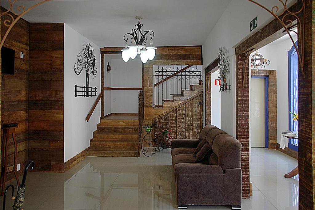 a living room with a couch and a staircase at Pousada Solar Das Gerais in Tiradentes