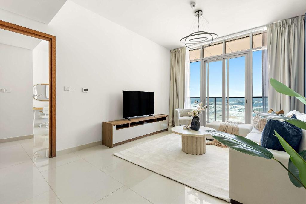 ein Wohnzimmer mit einem TV und einem großen Fenster in der Unterkunft Silkhaus Executive 2BDR in Al Reem Island in Abu Dhabi