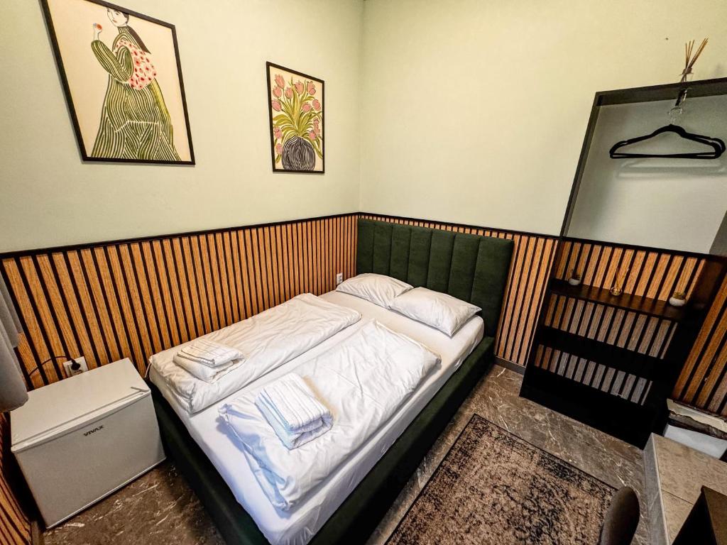 a small bedroom with a bed with white sheets at Cozy Modern Studio in Debrecen