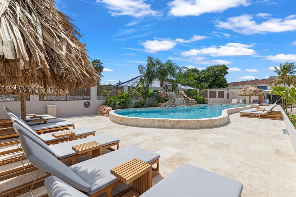a patio with chairs and a swimming pool at NÔA Curacao in Willemstad