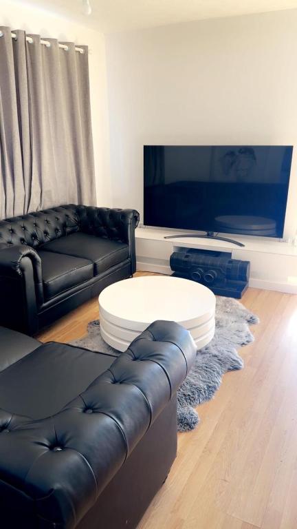 a living room with a leather couch and a table at Home in Colchester in Colchester