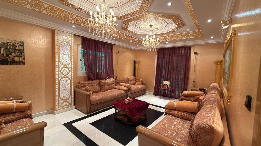 a large living room with couches and a chandelier at Cosy Apartment in Madinah in AR Rummanah