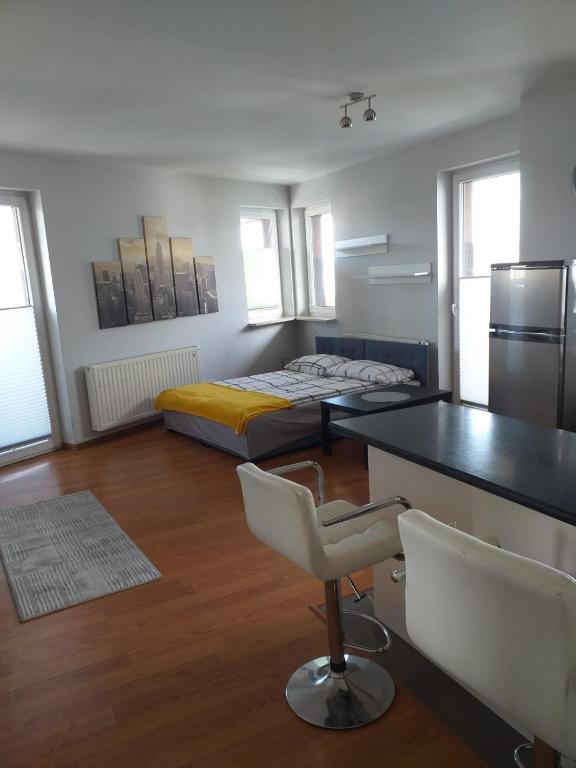 a bedroom with a bed and a desk and a chair at Apartamenty Centrum Studio Zagnańska in Kielce