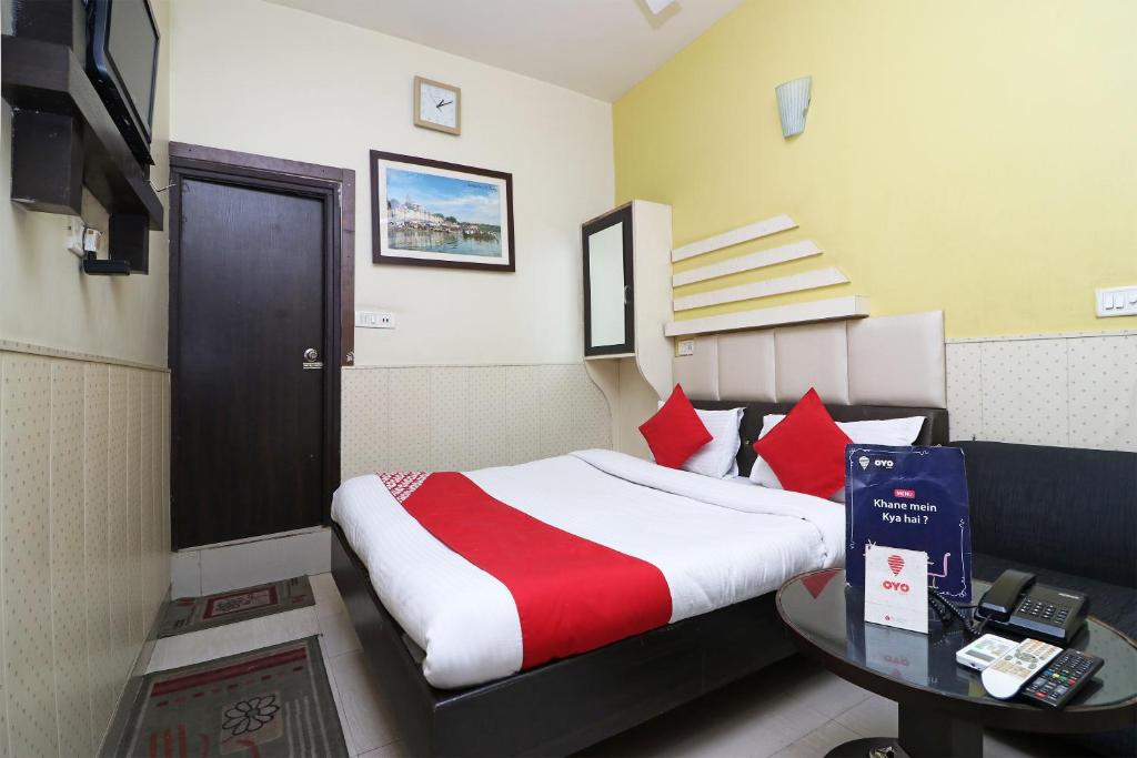 a hotel room with a bed and a table at Collection O Jhalwar Road in Kota