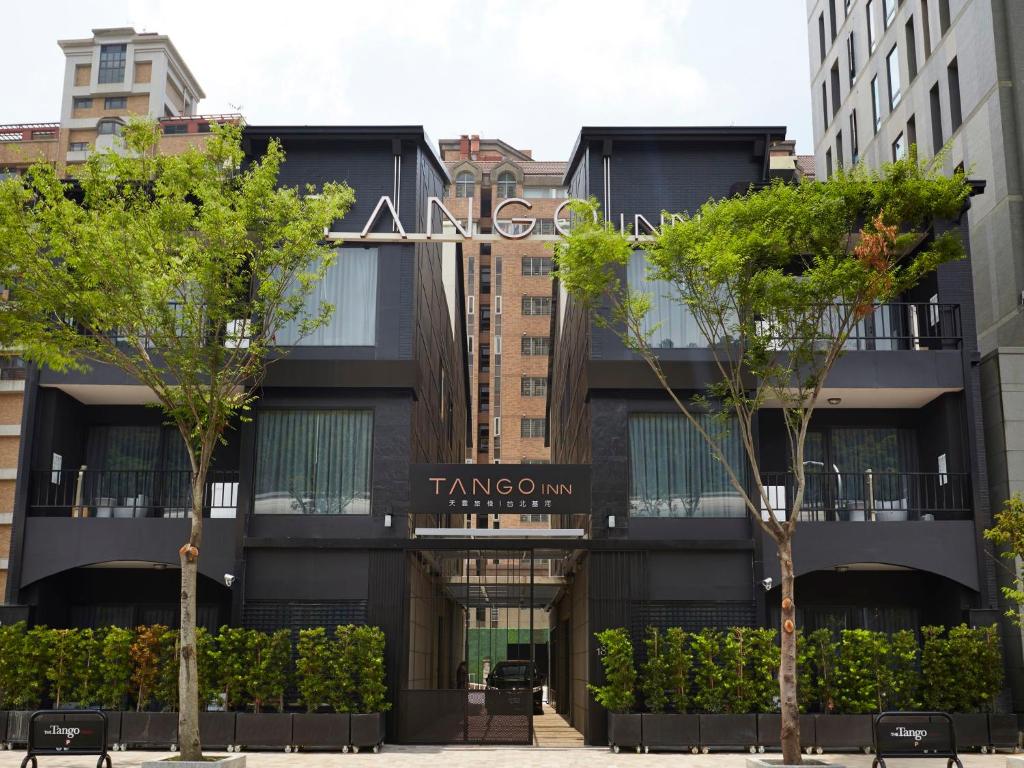 a black building with trees in front of it at Tango Inn Taipei Jihe in Taipei