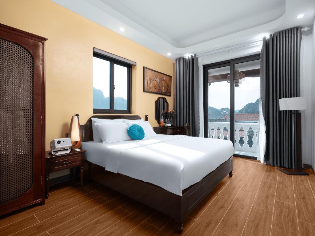 une chambre avec un lit et une grande fenêtre dans l'établissement Le Grande TamCoc Retreat, à Ninh Binh