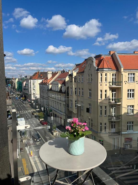 a vase of flowers sitting on a table on a balcony at Windows to the City Stylish Apartment in Poznań