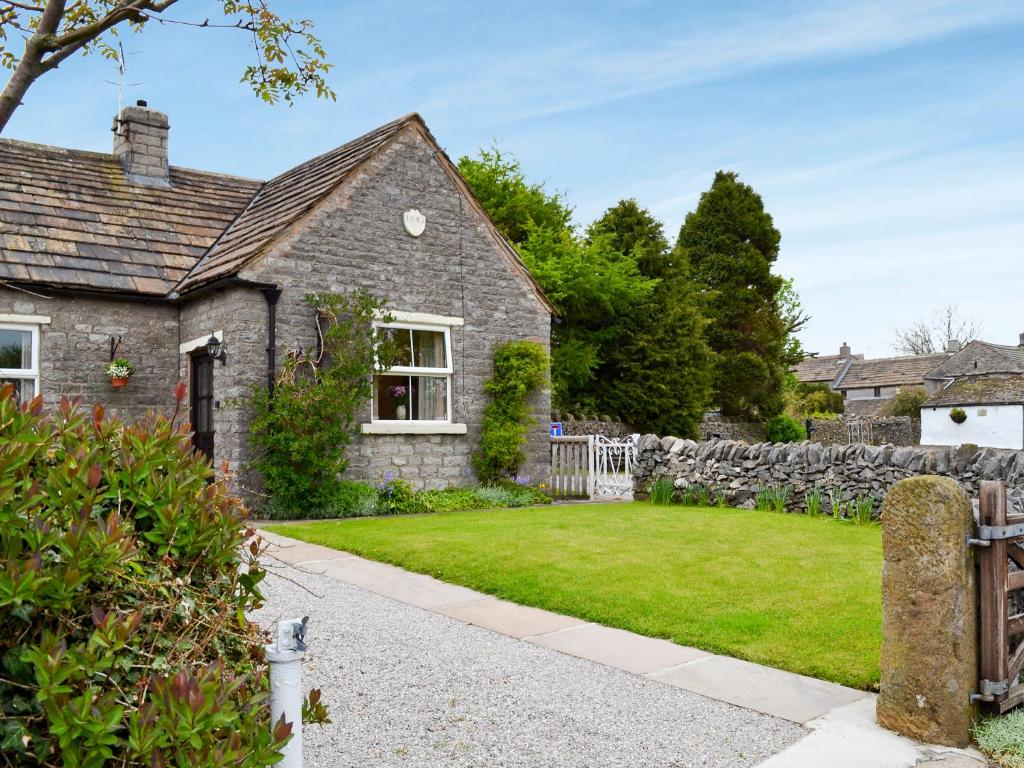 a stone house with a garden and a fence at Forest View in Peak Forest