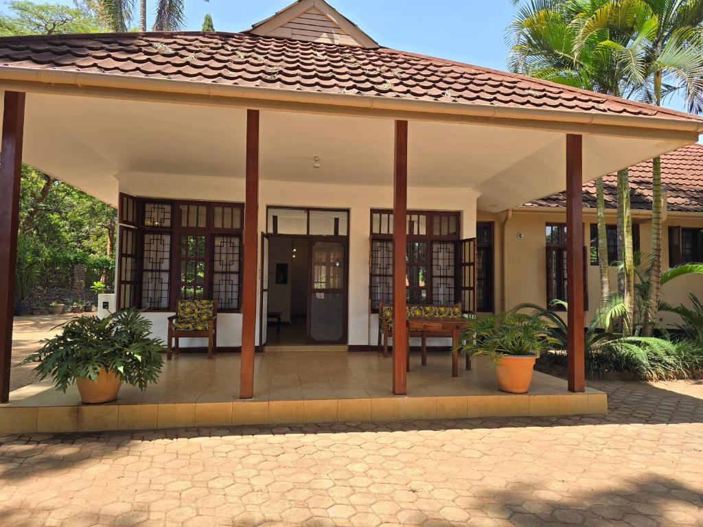 a pavilion with chairs and tables in front of a house at Sprunger Retreat - tulia homes in Moshi