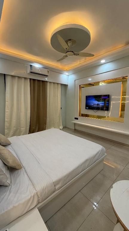 a bedroom with a large bed and a flat screen tv at HeavenStay Omaxe Hazratganj in Lucknow