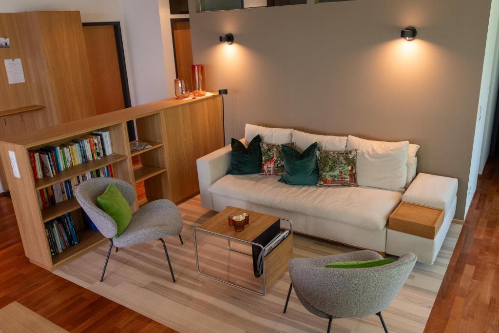 Una sala de estar con un sofá y una estantería. en Lebensfreude, en Dornbirn