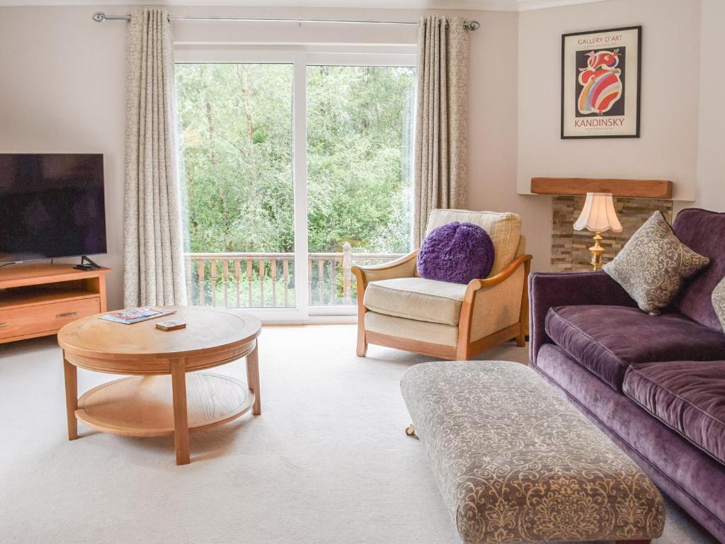ein Wohnzimmer mit Couch und Tisch in der Unterkunft Tamarchan Lodge in Ballachulish