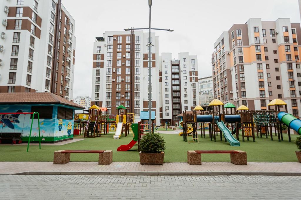 a playground in a city with tall buildings at Apartment lux in Chişinău
