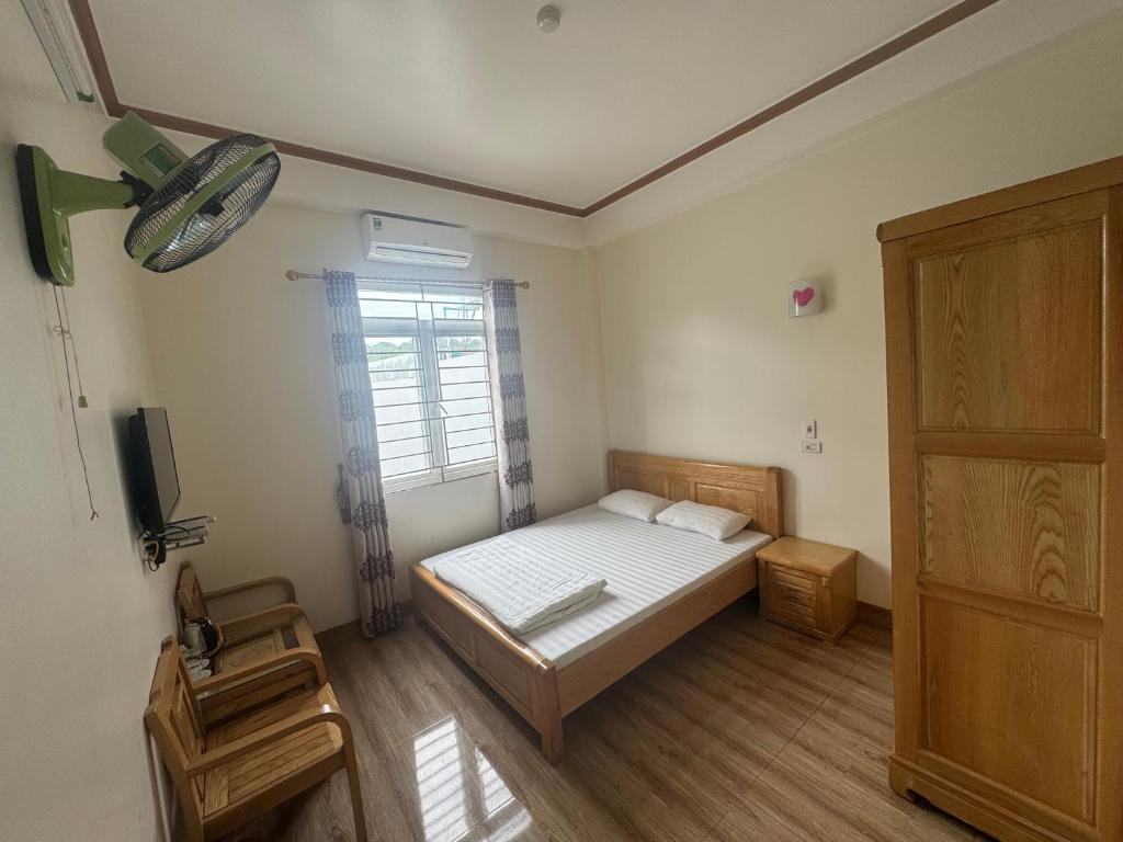 a small bedroom with a bed and a window at Hotel Hoàng Gia in Pan Linh