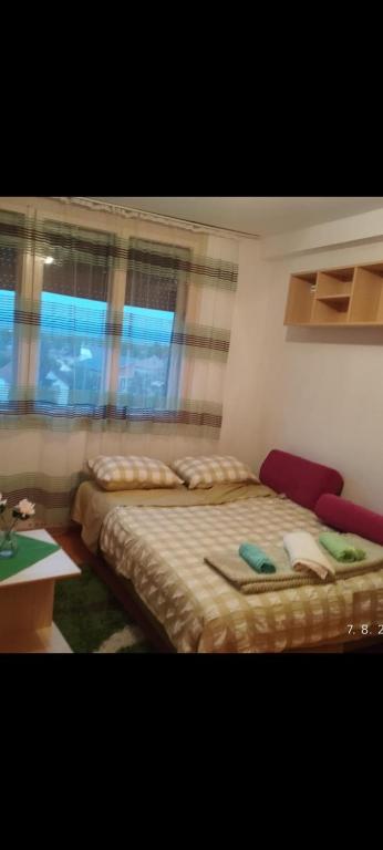 ein Schlafzimmer mit einem Bett, einem Schreibtisch und einem Fenster in der Unterkunft Apartman Milic in Jagodina
