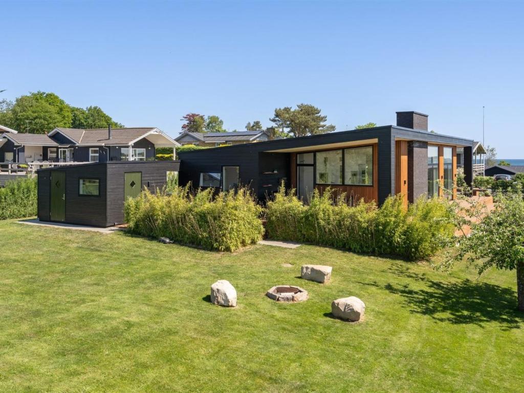 a black house with rocks in the yard at Holiday Home Karitte - 300m from the sea by Interhome in Hvidbjerg