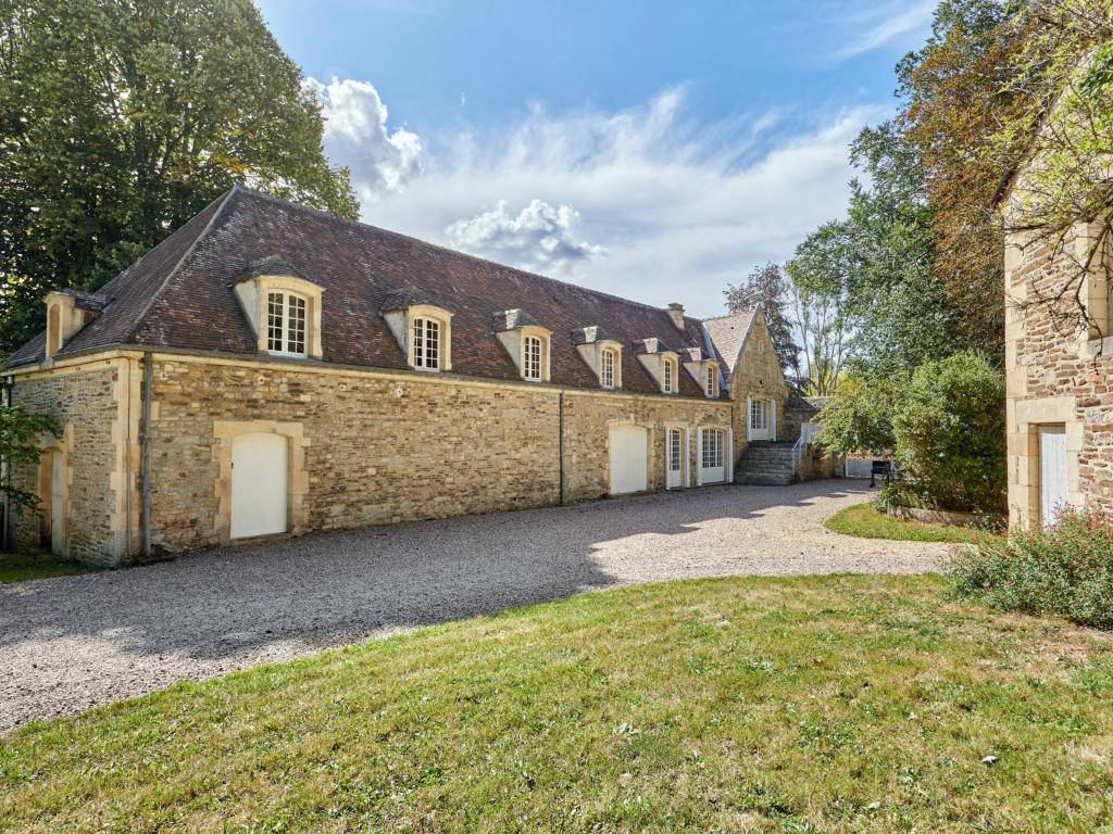 ein großes Backsteingebäude mit weißen Türen und Fenstern in der Unterkunft Holiday Home Le Pressoir de la laize by Interhome in Urville