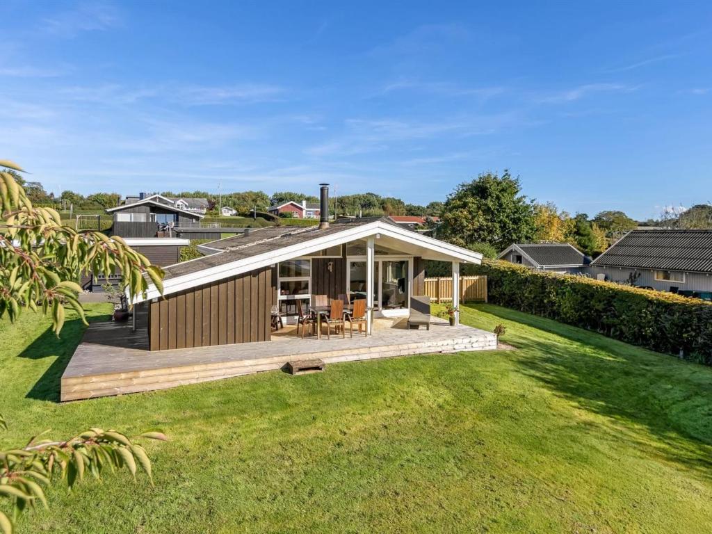 Holiday Home Quanna - 450m from the sea by Interhome في Hejlsminde: منزل به سطح خشبي في ساحة