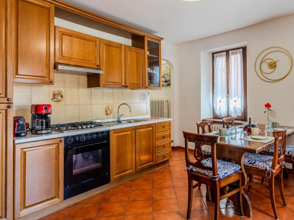 a kitchen with wooden cabinets and a table with a dining room at Holiday Home Papaveri e Papere by Interhome in Piano Porlezza