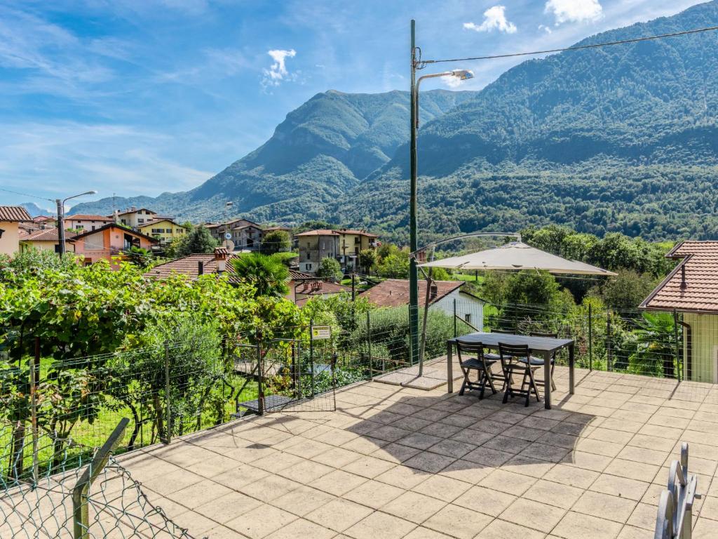 Holiday Home Papaveri e Papere by Interhome في Piano Porlezza: فناء مع طاولة وإطلالة على الجبال