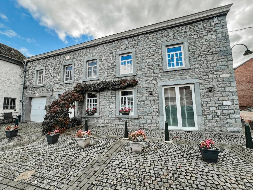 a stone building with potted plants in front of it at Maison Aimée Cottage 9 people in Rochefort