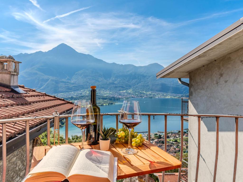 - une table avec des verres à vin et un livre sur un balcon dans l'établissement Holiday Home Stone House by Interhome, à Gera Lario