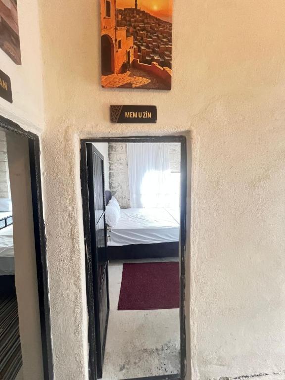 a door into a room with a bed in it at Mem U Zin in Midyat