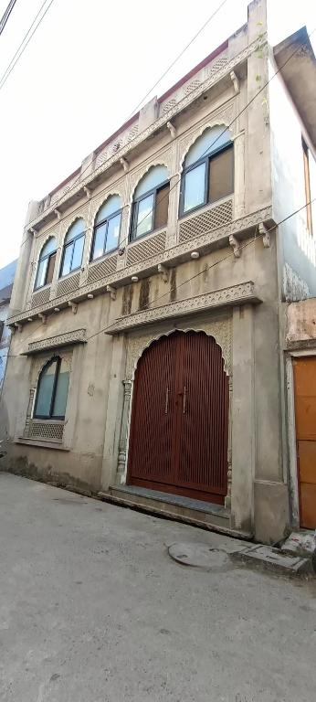 a building with a red gate and a red door at Rajawat house in Tonk City