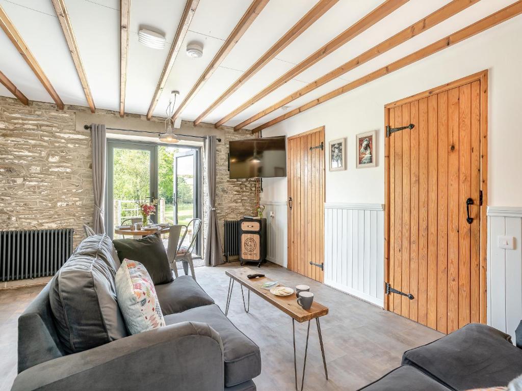 a living room with a couch and a table at The Old Cowsheds 2 - Shippon - Uk49787 in Cribyn