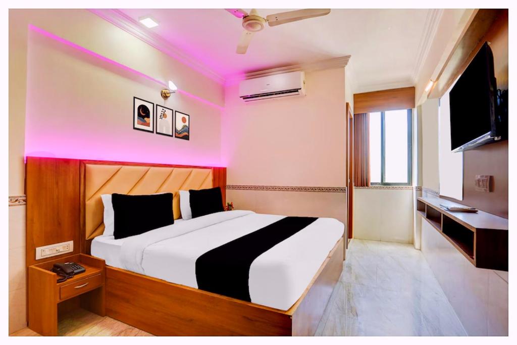 1 dormitorio con 1 cama grande con iluminación rosa en HOTEL G-D PREMIUM BHUBANESWAR - Air conditioned - free wifi & parking service available - Near Temple - A Top Rated Hotel, en Cuttack