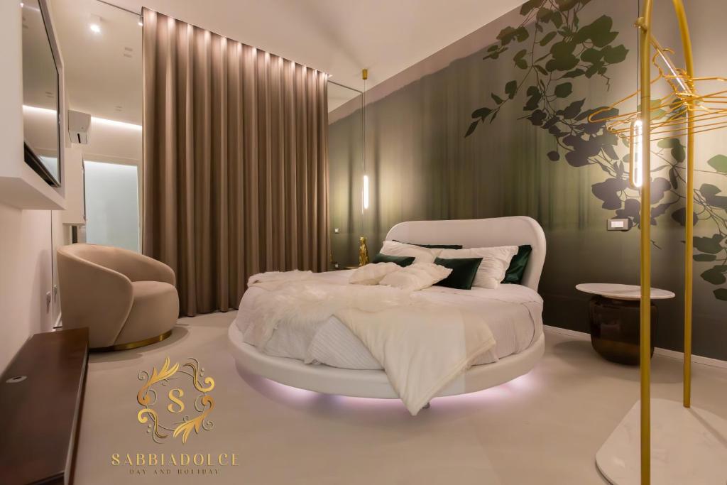 a bedroom with a white bed and a chair at Sabbiadolce in Bellaria-Igea Marina