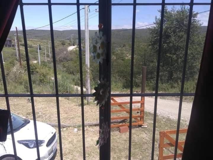 ein Fenster mit Blick auf einen Hof mit einem weißen Auto in der Unterkunft Rincón Peralta Córdoba in Valle Hermoso