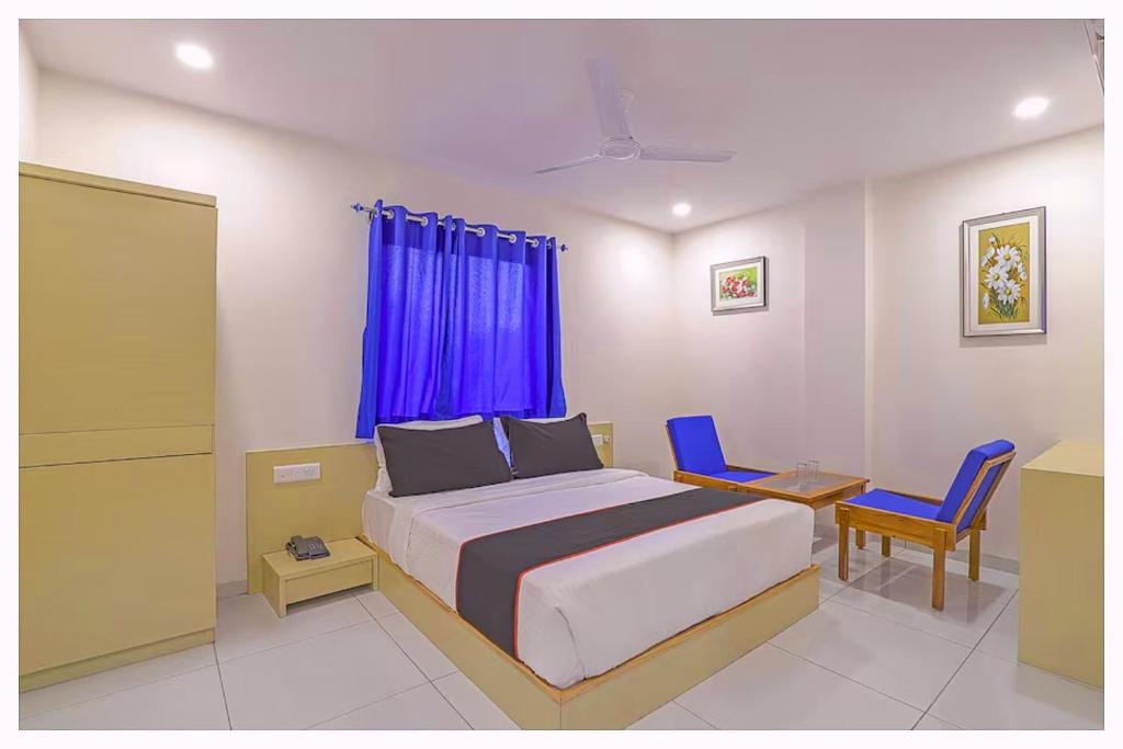 a bedroom with a bed and two blue chairs at HOTEL MORYA-CLASSIC Near APJ Park - Fully Air Conditioning Rooms - With free Parking, Free Wifi, Restaurant & Room Service Facilities - A Top Rated Hotel in Cuttack