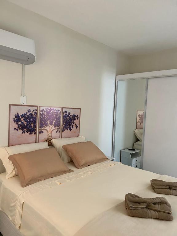 ein Schlafzimmer mit einem großen weißen Bett und einem Fenster in der Unterkunft Apto 2 suítes em Aracajú a 300 metros da Orla in Aracaju