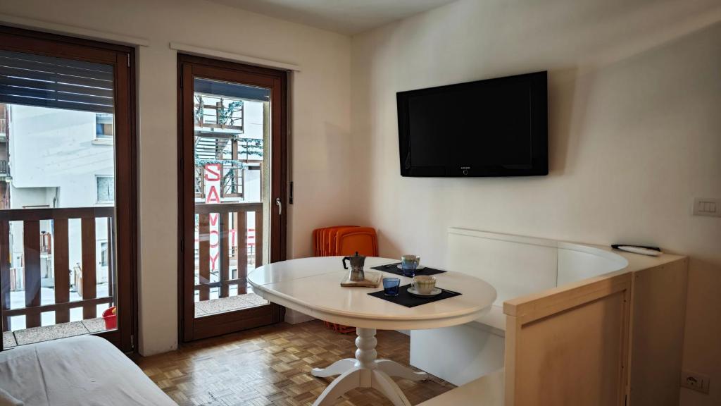 セストリエーレにあるHostdomus - City Hall Suiteのテーブルと壁掛けテレビ付きの部屋