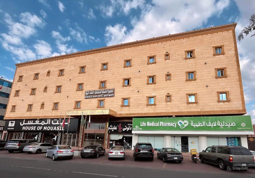 a large building with cars parked in front of it at نسيم الشفا للشقق الفندقية in Taif