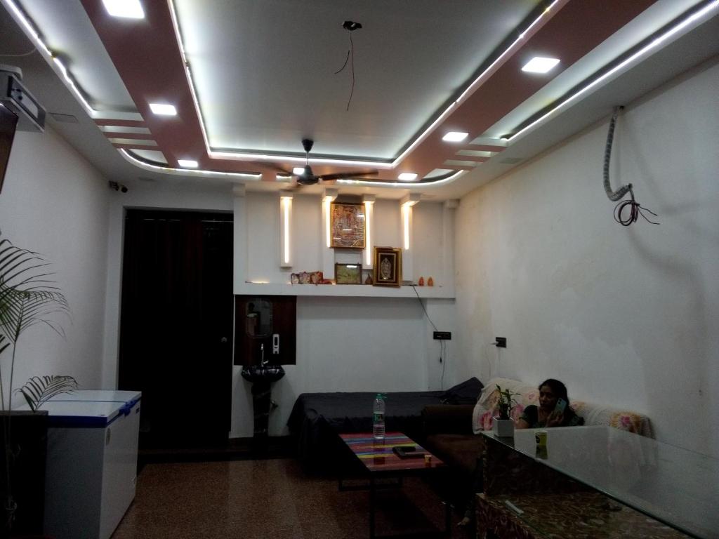 un hombre está sentado en un sofá en una sala de estar en The banaras residency, en Varanasi