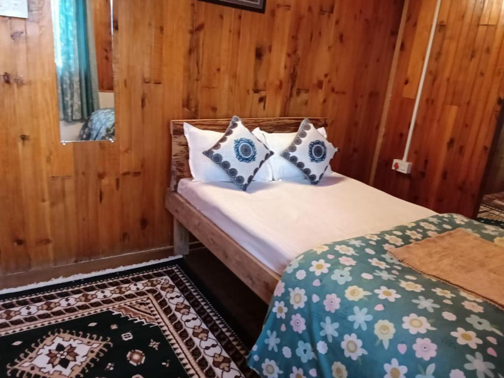 a bedroom with a bed with pillows on it at Bloomfield Farmhouse 2 in Darjeeling