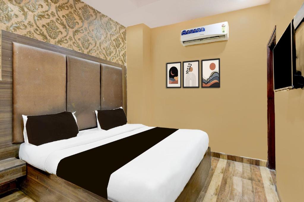 Un dormitorio con una gran cama blanca en una habitación. en Hotel O Lotus Inn, en Faridabad