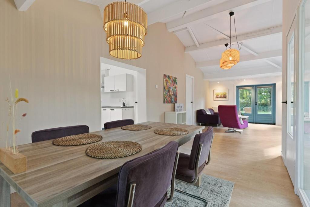 a dining room with a large wooden table and chairs at Boerderijwoning 't Boetje in Heiloo