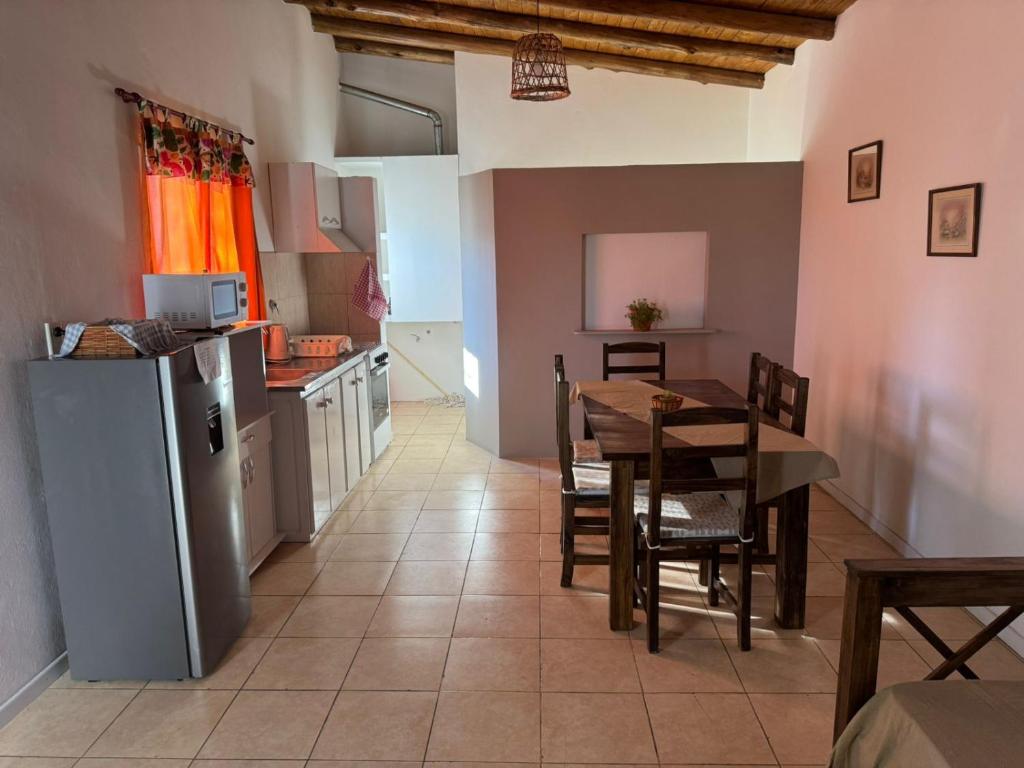 une cuisine et une salle à manger avec une table et un réfrigérateur dans l'établissement Ricon de malvones vintage, à General Alvear