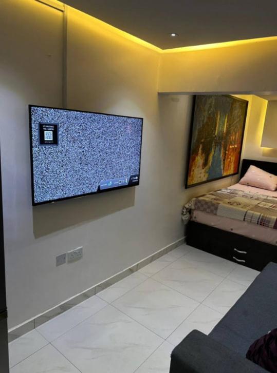 a room with a flat screen tv on a wall at Bright apartments in Abuja in Abuja