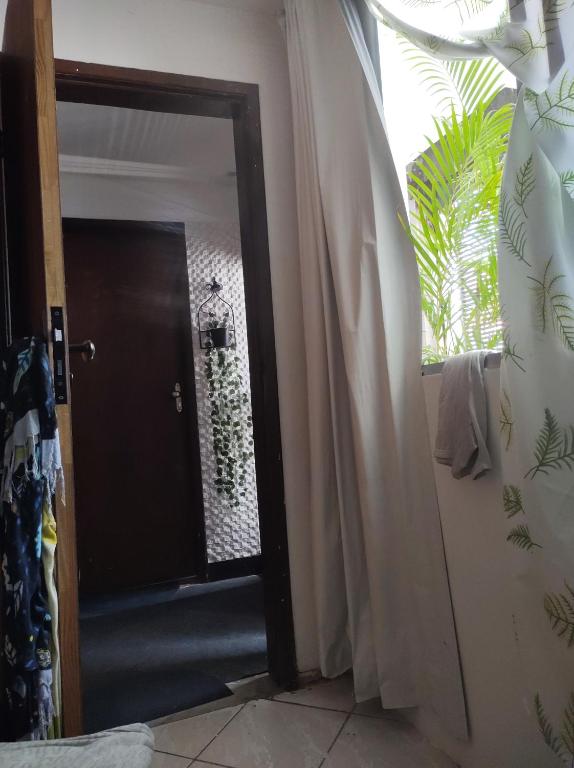 a door to a room with a window and a curtain at CASACOMPART Quarto individual in Salvador