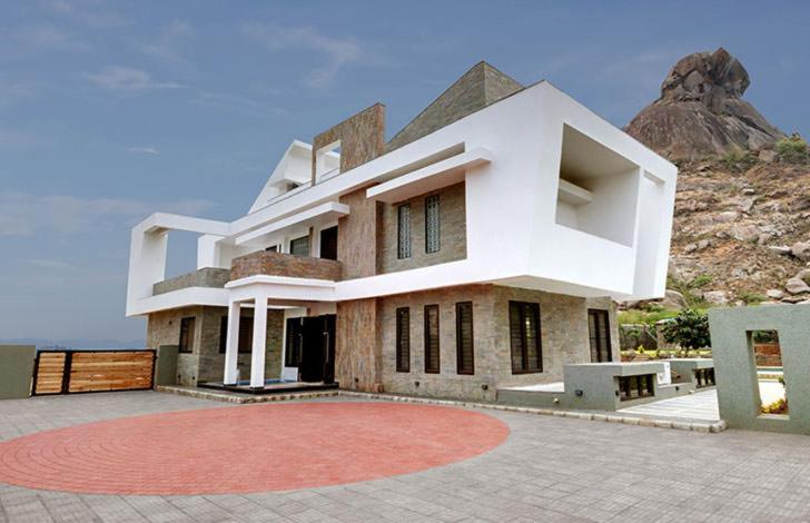 una gran casa blanca con una alfombra roja delante de ella en Chacha Villa, en Ābu Road